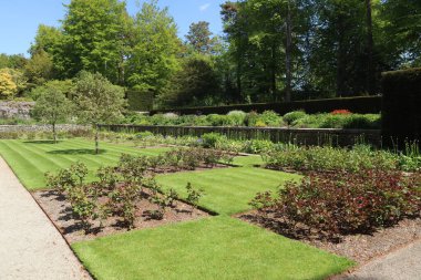 Devon, İngiltere 'deki Dartmoor Ulusal Parkı' nın kıyısındaki resmi bir İngiliz kır evinin bahçesinde çimenlik alan boyunca uzanan bir çakıl yolu.