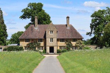 A substantial house in the grounds of an old English country house