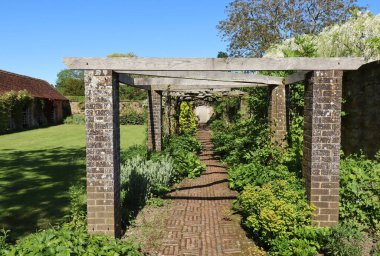 A wooden pergola in the grounds of an old English country house