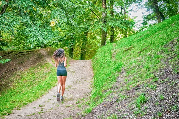 Kobieta sportowiec i biegacz działa na Park: trening jog dobrego samopoczucia. Camaldoli, Casentino, Toskania, Włochy. — Zdjęcie stockowe