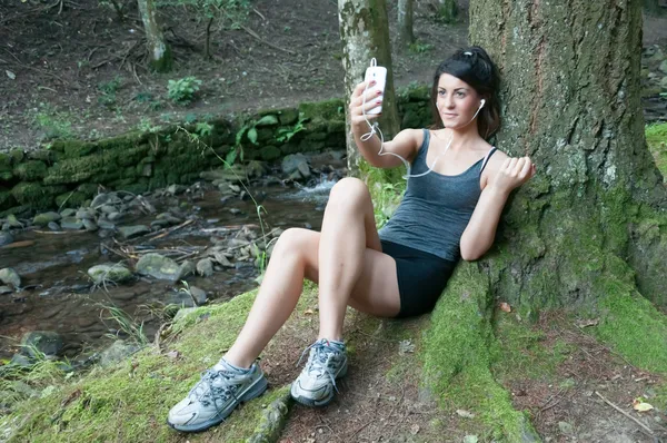 Piękna dziewczyna gra na inteligentny telefon w parku — Zdjęcie stockowe