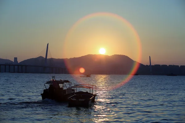 Hong kong scény, loď prochází slunce výbuch v hluboké zátoky moře — Stock fotografie