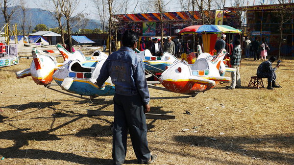 ПОХАРА, НЕПАЛЬ - ЯНВАРЬ 1: Неизвестный человек ремонтирует оборудование во время Фестиваля на потрепанном карнавале в Похаре 11 января 2010 года в Похаре
