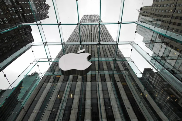 NUEVA YORK 5 DE ABRIL: el Apple Store con el logotipo grande bajo el mal tiempo en la Quinta Avenida en Nueva York el 5 de abril de 2012. la tienda está diseñada como la caja de vidrio exterior sobre la sala de exposición subterránea — Foto de Stock