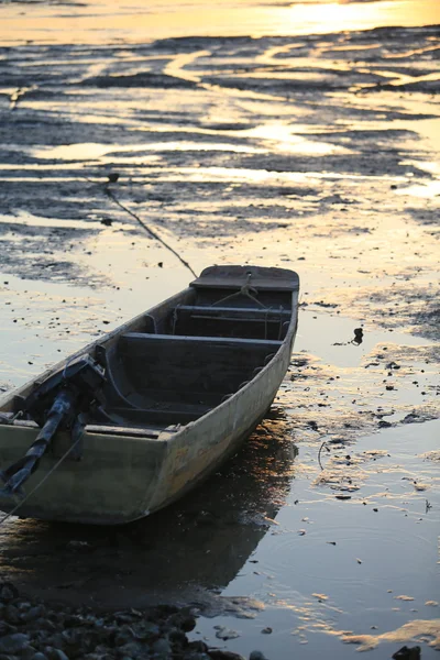 Ola de marea hacia atrás con el barco varado — Foto de Stock