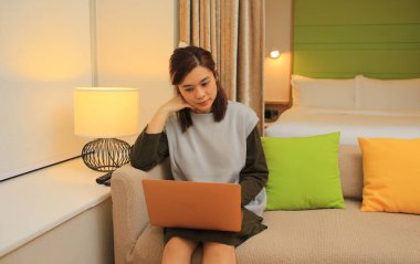 Genç bayan serbest yazar odasında kanepede çalışıyor. 