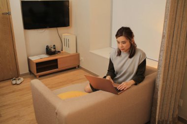 Odasında çalışan Asyalı serbest çalışan bir kadın.