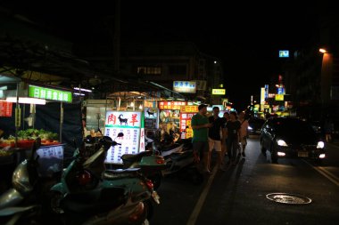 Taichung, Tayvan - 26 Şubat 2015: İnsanlar ve biniciler Fengjia Gece Pazarı 'nda sokakta meşguller. Fengjia Gece Pazarı en ünlü gece pazarlarından biridir.  