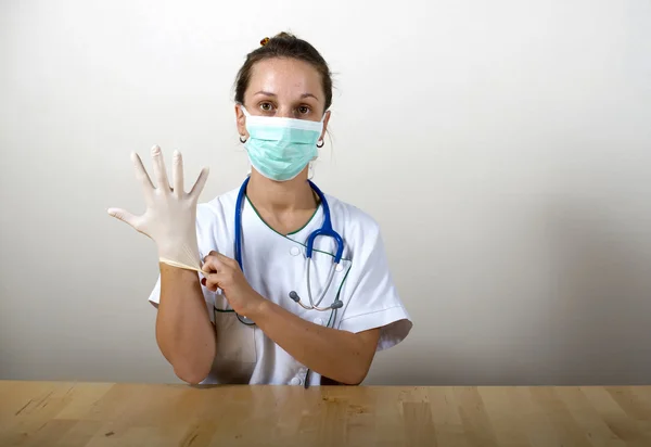 A young woman doctor and latex gloves — Stock Photo, Image