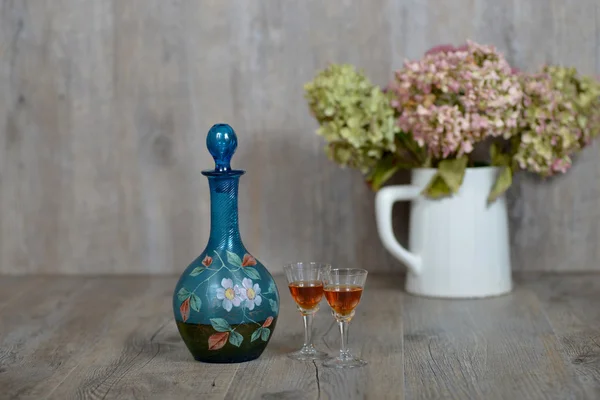 Former decanter with two small glasses with liqueur — Stock Photo, Image