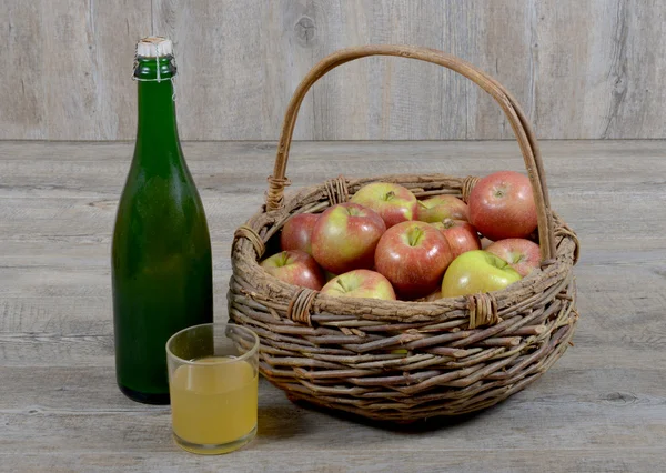 Koszyka jabłko i butelki ze szkła cydr — Zdjęcie stockowe