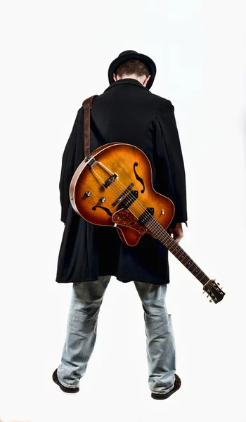 En gitarrist med sin gitarr i ryggen — Stockfoto