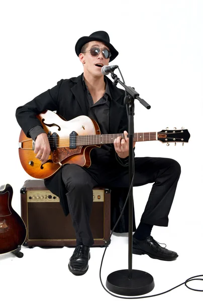 Kytarista zpívá, sedí na zesilovač — Stock fotografie