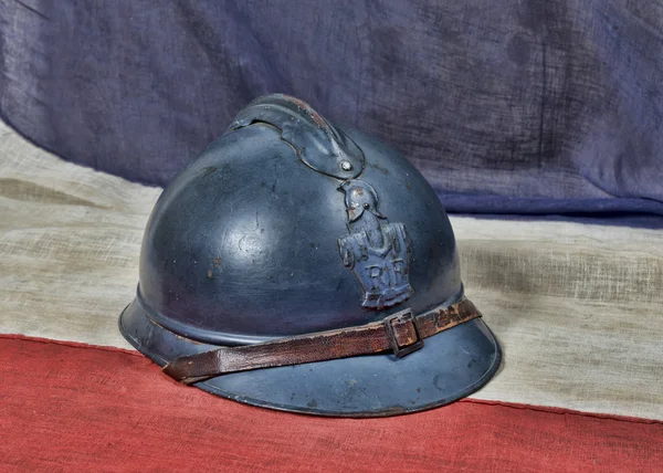 Французский ww 1 шлем на старинном французском флаге — стоковое фото