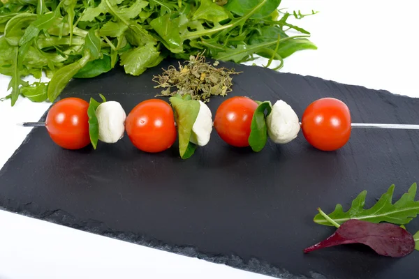Szaszłyk z pomidorów na Łupek z sałatką — Zdjęcie stockowe
