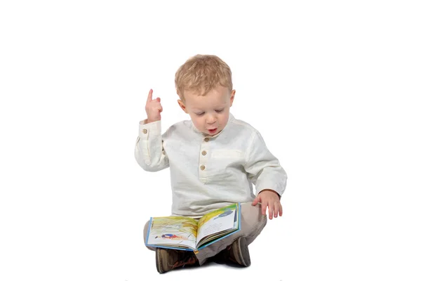 Bebé sentado con las piernas cruzadas leyendo un libro — Foto de Stock