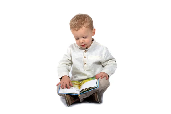 Bebé sentado con las piernas cruzadas leyendo un libro — Foto de Stock