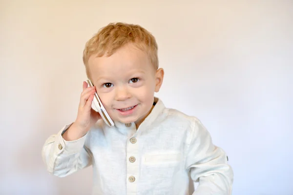 Baby smiles with a mobile phone — Stock Photo, Image