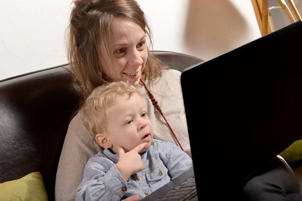 Mladá matka a její dítě, při pohledu na počítači — Stock fotografie