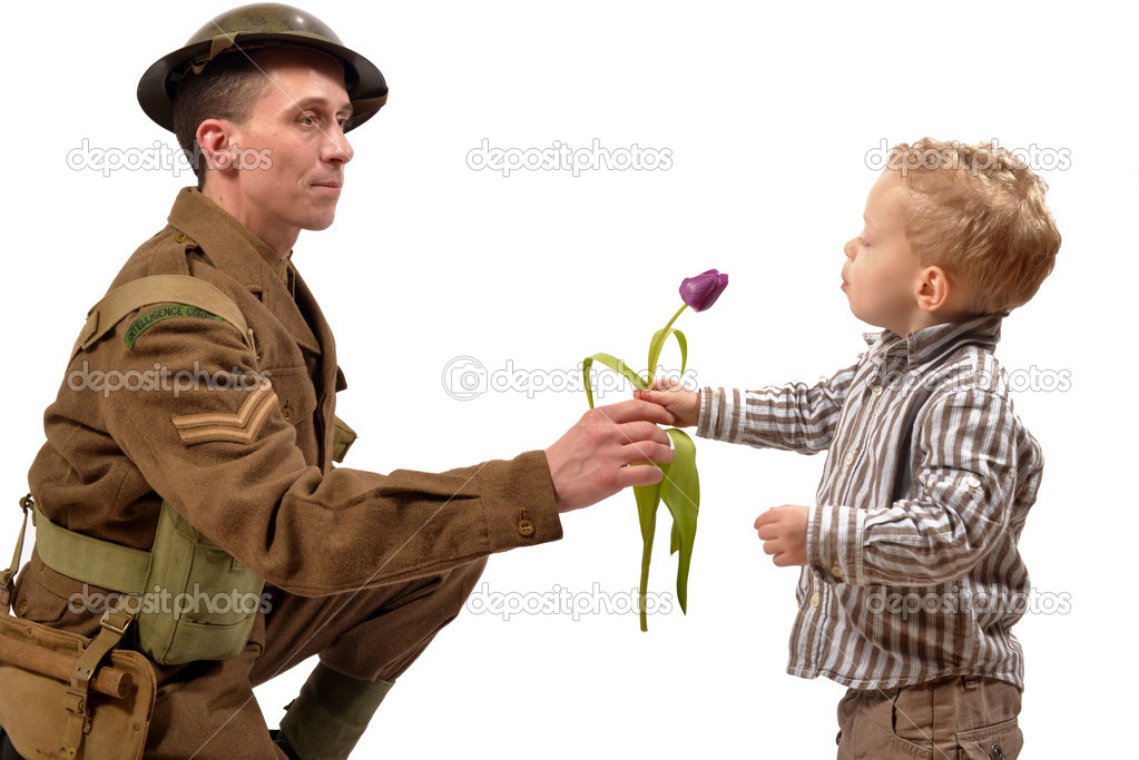 a young child gives a flower to a British soldier