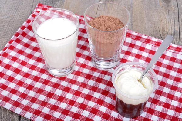 लाल नॅपकिनवर चॉकलेट दूध आणि चॉकलेट पावडरसह दही — स्टॉक फोटो, इमेज