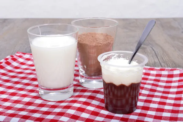 Yogurt con latte al cioccolato e cioccolato in polvere su un tovagliolo rosso — Foto Stock