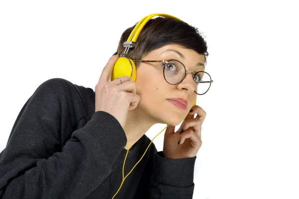 Jovem mulher usando fones de ouvido ouvindo música — Fotografia de Stock