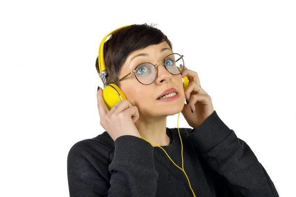 Jovem mulher usando fones de ouvido ouvindo música — Fotografia de Stock