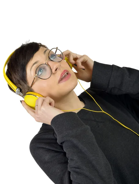 Jovem mulher usando fones de ouvido ouvindo música — Fotografia de Stock