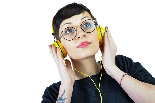 Jovem mulher usando fones de ouvido ouvindo música — Fotografia de Stock