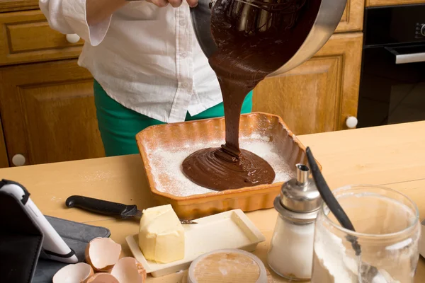 Woman hands pouring melted chocolate into a mold — Stock Photo, Image