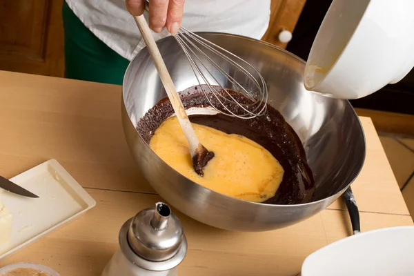 Woman hands mixing chocolate with eggs — Stock Photo, Image
