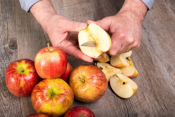 Handen van een man, snijden een appel — Stockfoto