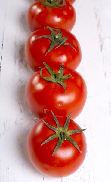 Tomates en vísperas de madera blanca — Foto de Stock