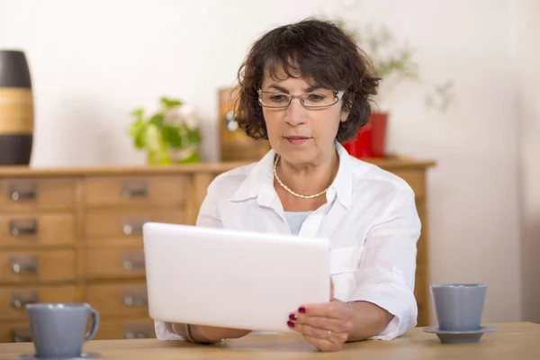 Una mujer de mediana edad que usa una tableta de computadora —  Fotos de Stock