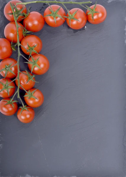 Tomates pequeños presentados en un plato de pizarra — Foto de Stock