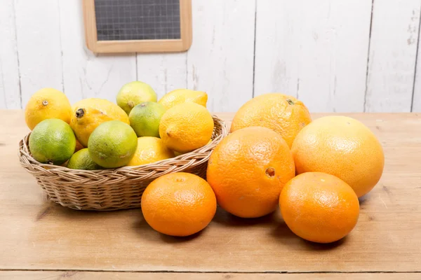 Oranges, lemons and grapefruit presented in a small basket — Stock Photo, Image