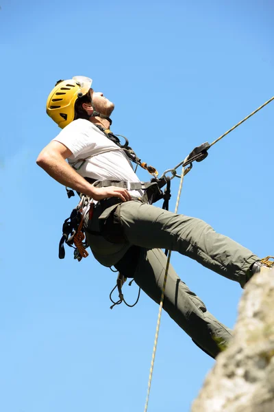 Steeplejack escalando uma parede de rocha — Fotografia de Stock