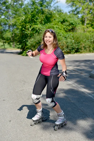 Ganska ung kvinna gör rullskridsko på ett spår — Stockfoto