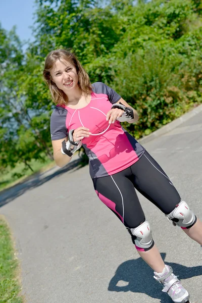 Hübsche junge Frau beim Rollschuhlaufen auf einer Bahn — Stockfoto