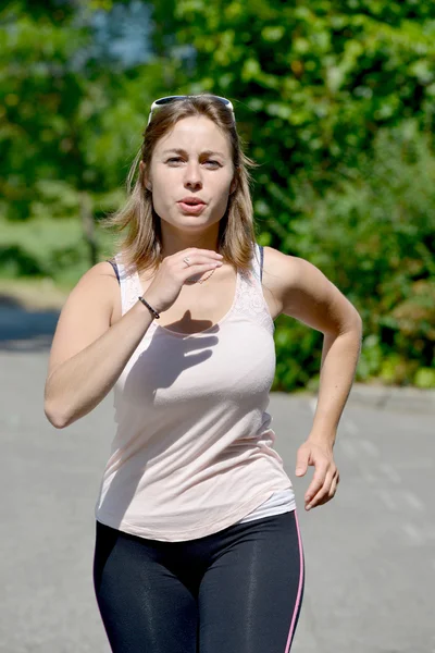 Спортивна молода жінка біжить по дорозі — стокове фото