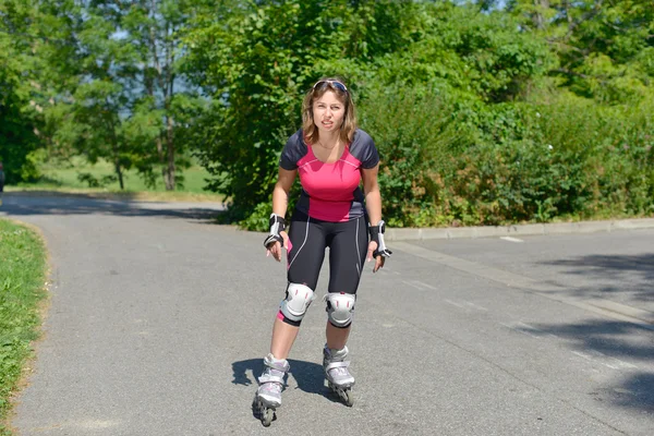 Jolie jeune femme faisant du roller sur une piste — Photo