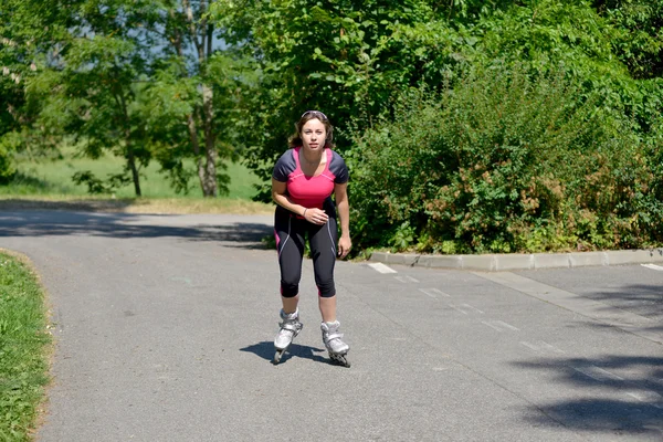 Pretty young woman doing rollerskate on a track — Stock Photo, Image