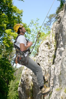 genç adam bir kaya duvarı tırmanışı