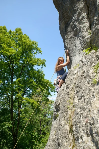 Giovane donna arrampicata su una parete di roccia — Foto Stock