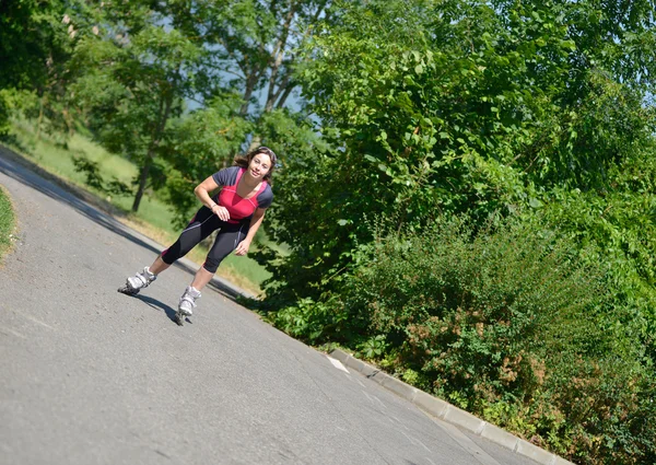 Αρκετά νεαρή γυναίκα που κάνει rollerskate σε ένα κομμάτι — Φωτογραφία Αρχείου