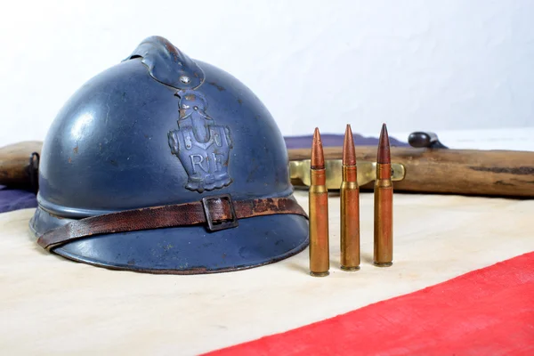 French helmet of the First World War with a gun on a red white b — Stock Photo, Image