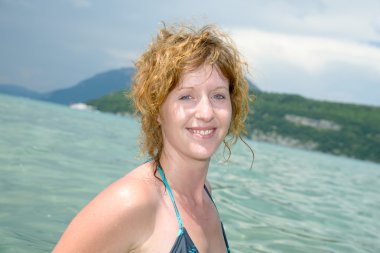 Küçük kızıl saçlı ve bir gölde doğal banyo