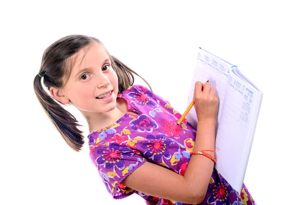 Schoolmeisje schrijven op agenda — Stockfoto