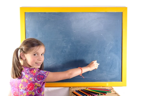 Schoolmeisje schrijven op een schoolbord — Stockfoto